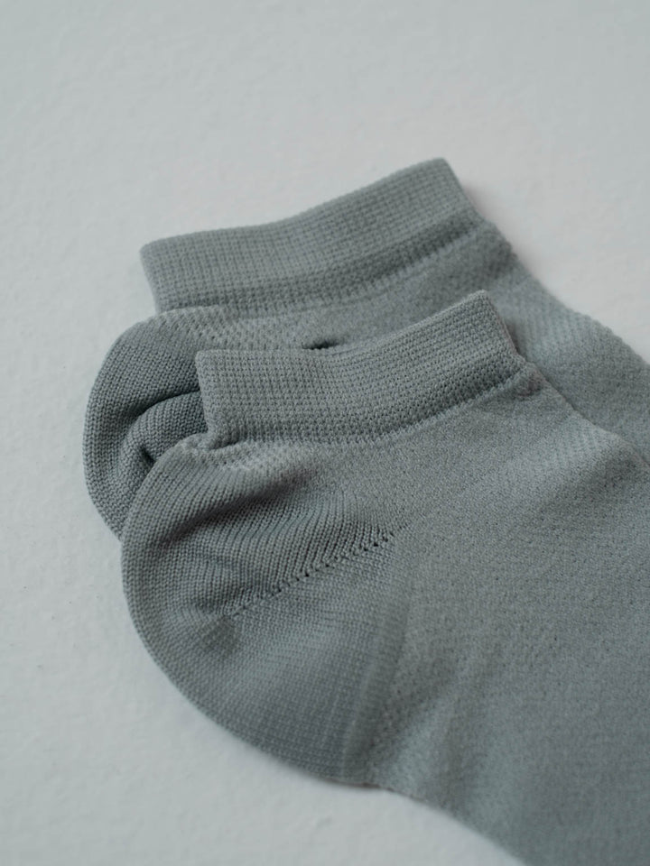 Vista detallada de la parte superior de las medias tobilleras acaneladas color gris