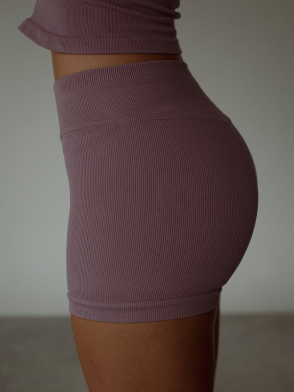 Vista lateral mini short deportivo sin costuras control abdomen en poliamida.