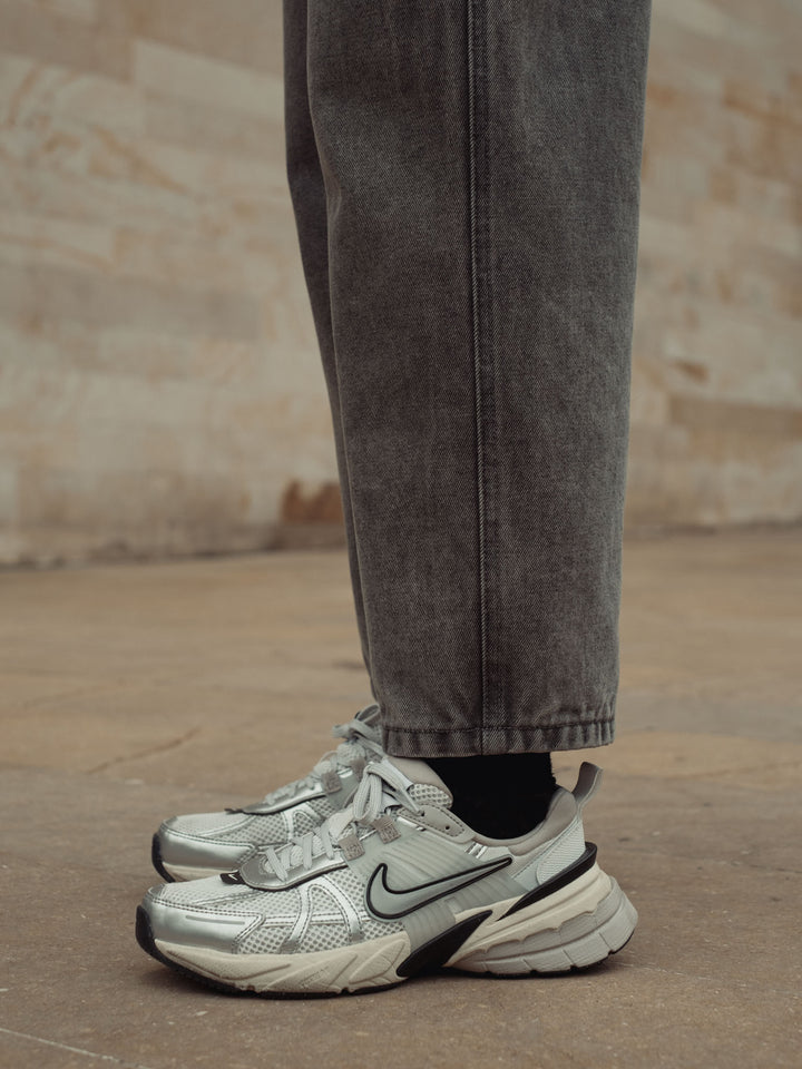 Vista detallada del ruedo al corte a la altura del tobillo del jean color gris vintage