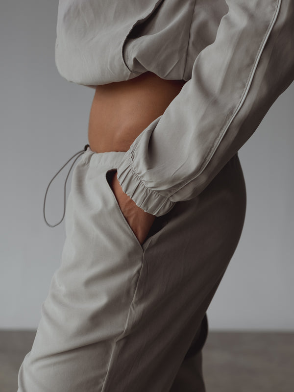 Detalle vista lateral bolsillo de pantalón gris.