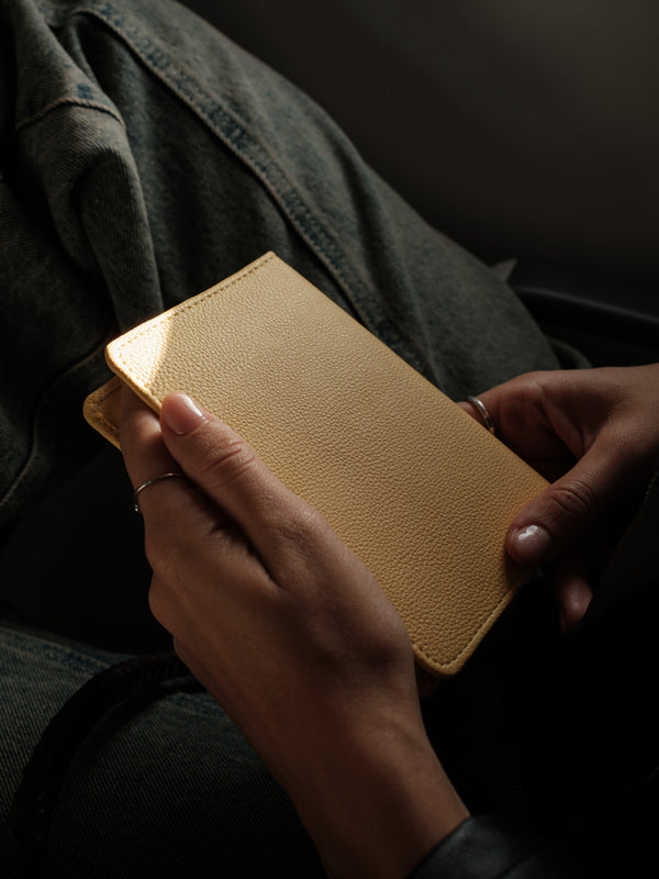 Vista posterior de porta pasaporte amarillo con textura.