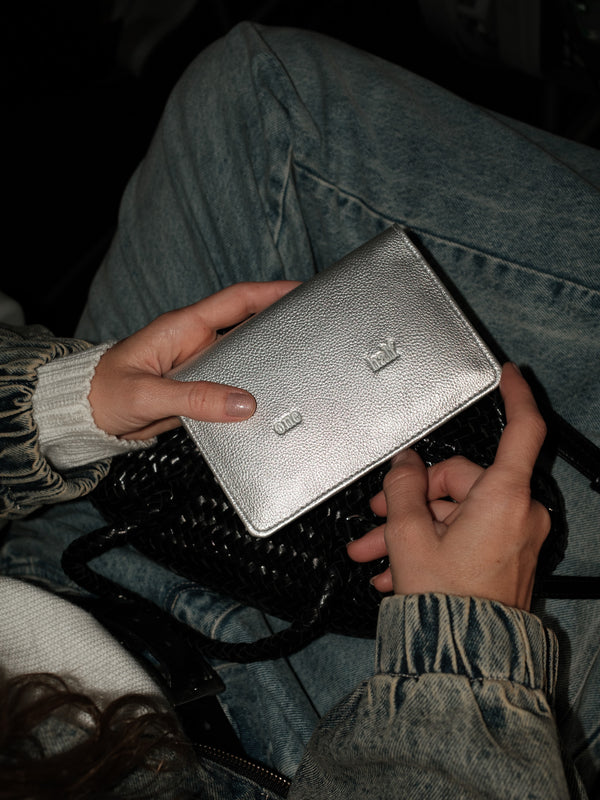 Vista frontal de porta pasaporte plata con grabado "One Half" centrado.