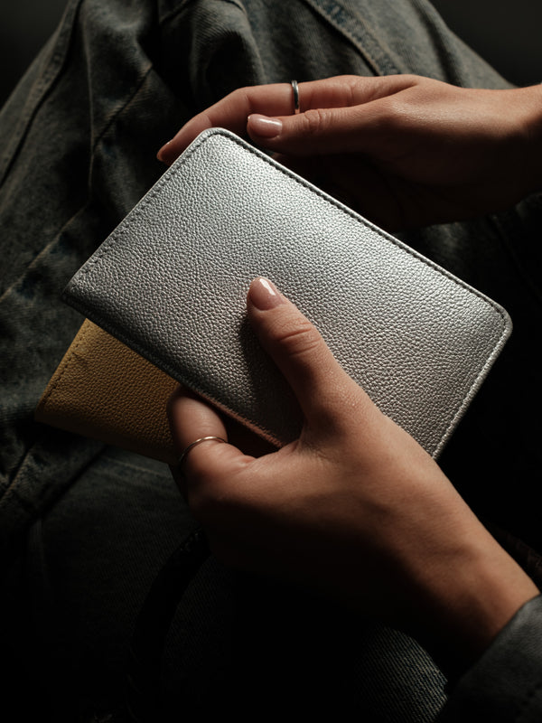 Vista posterior de porta pasaporte plata con textura.