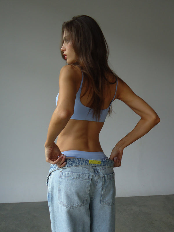 Modelo de espalda con ropa interior azul sin costuras.
