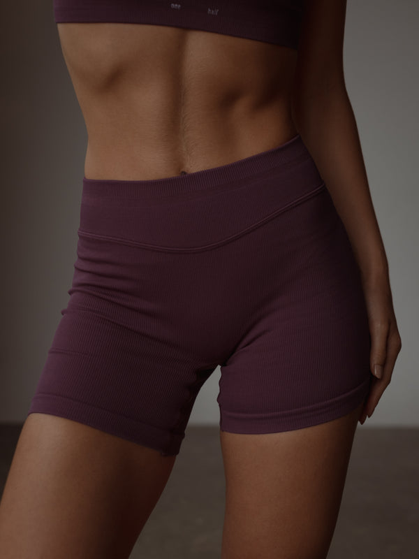 Vista frontal short deportivo vino pretina curva sin costuras.