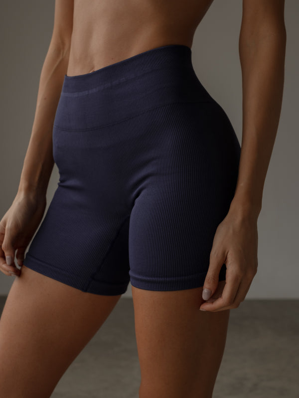 Modelo usando short deportivo púrpura pretina alta. 