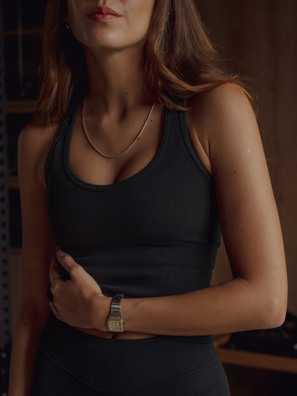 Modelo usando top deportivo negro escote en U sin costuras.