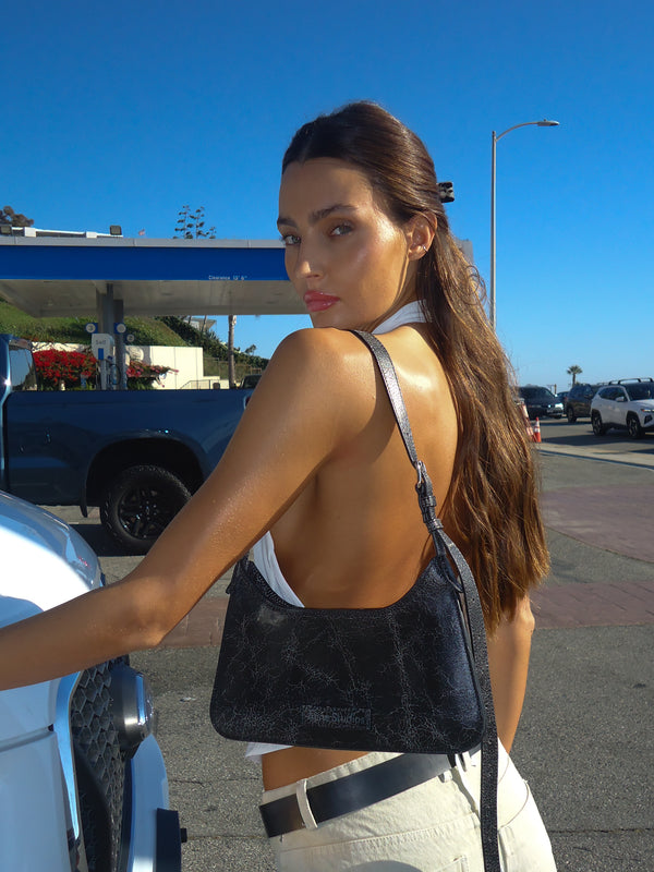 Modelo de espalda usando top halter espalda descubierta con jean crema.