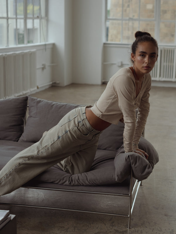 Modelo de lado usando top anudado manga larga taupe.