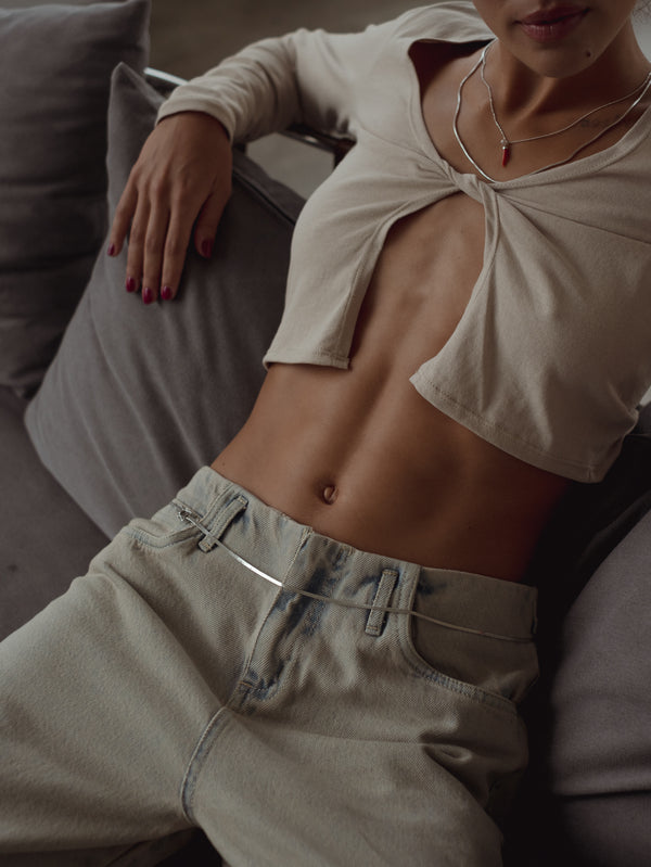 Vista superior top escotado con nudo frontal manga larga en color taupe.