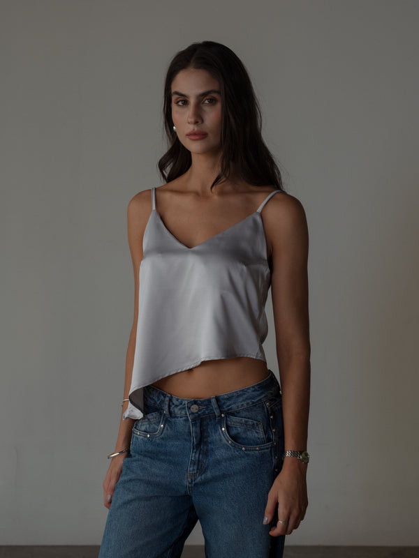 Modelo con jean azul y top de tiras satinado plata escote V.