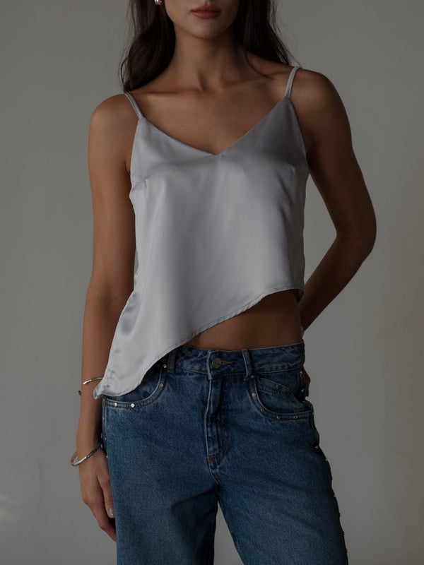 Vista frontal modelo con top satinado de tiras escote en V ruedo diagonal.