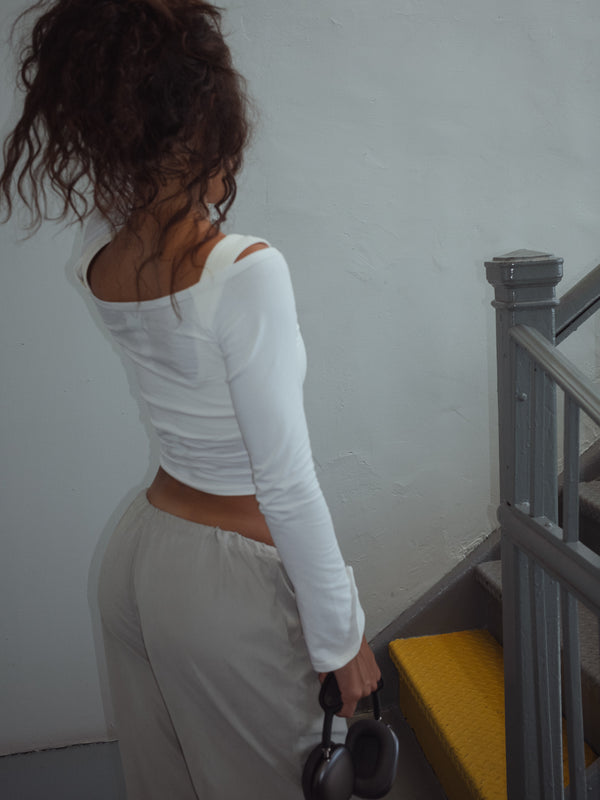 Modelo con cabello recogido dando vista posterior de top crudo.