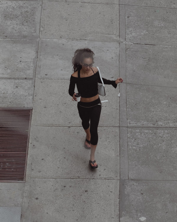 Vista superior de modelo caminando mientras toma café.