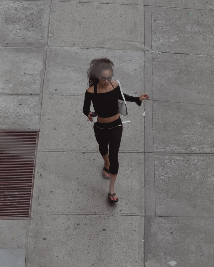 Vista superior de modelo caminando mientras toma café.