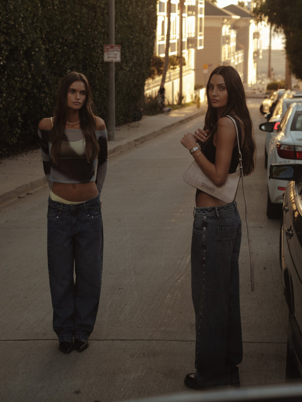 Dos modelos en la calle usando jeans y tops casuales para mujer. 