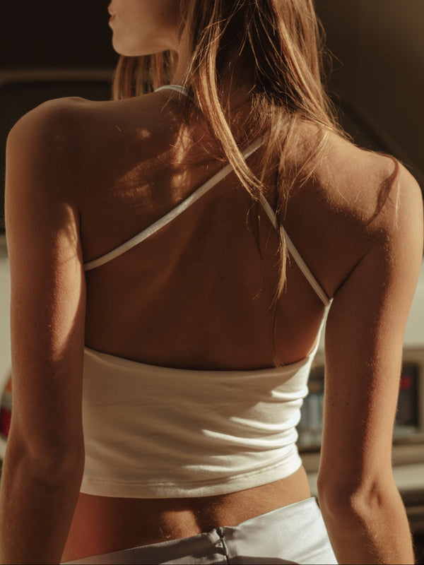 Vista posterior modelo usando crop top de tiras de espalda cruzada crudo.