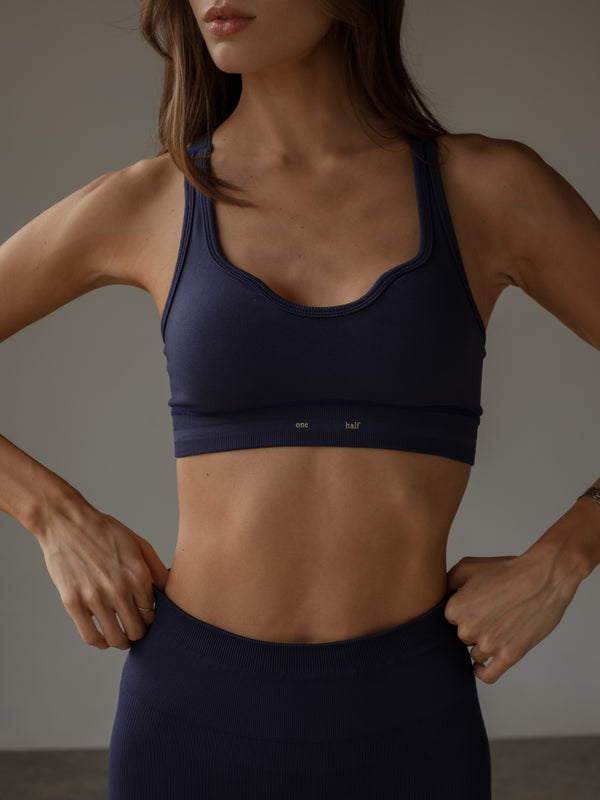 Vista frontal modelo usando top deportivo púrpura escote en U.