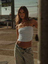Modelo usando crop top strapless drapeado azul claro con jean.