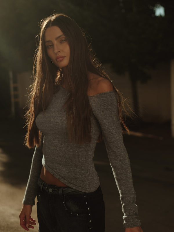 Modelo usando top tejido manga larga gris con jean gris doble lavado.