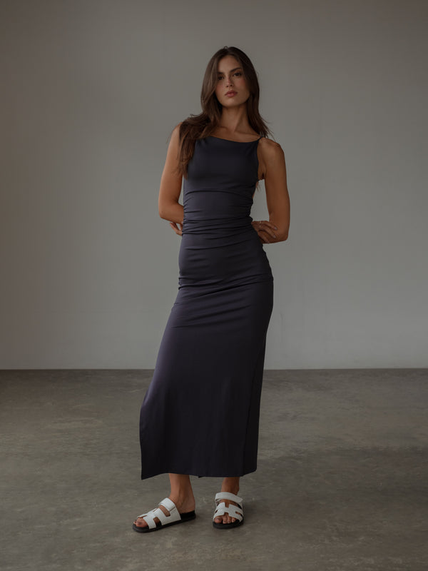 Modelo usando vestido largo drapeado púrpura.