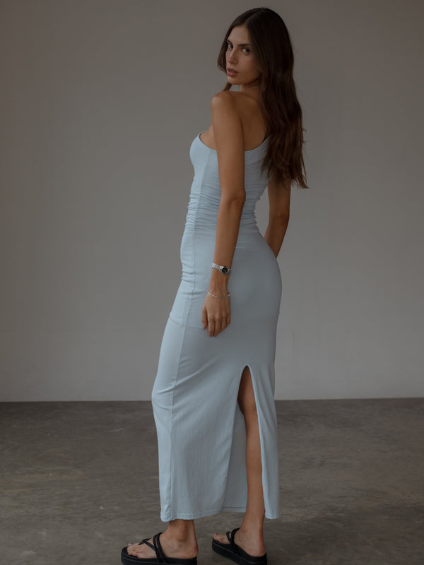 Vista posterior de vestido largo azul claro con abertura en falda.