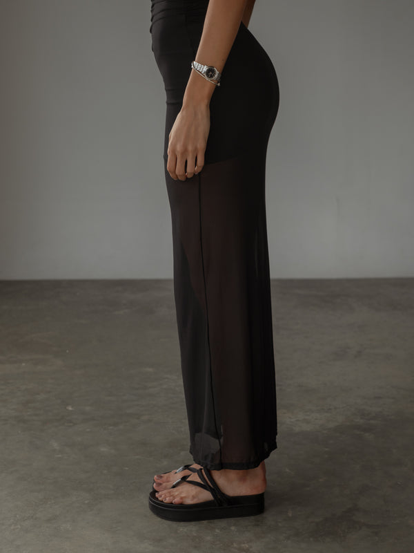 Vista lateral de vestido negro con transparencia y forro interno.