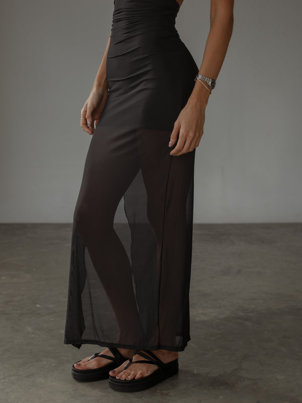 Vista de falda con transparencia de vestido negro ajustado.
