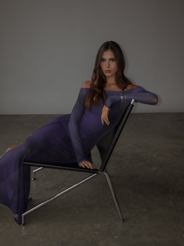 Modelo sentada usando vestido manga larga púrpura en mesh.