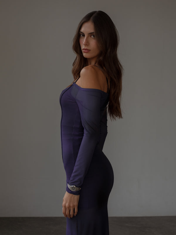 Vista lateral modelo usando vestido de hombros descubiertos púrpura.