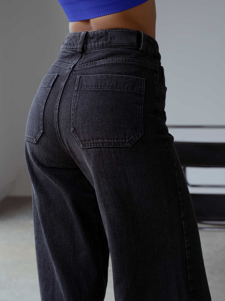 Vista a detalle de los bolsillos posterior del jean negro.